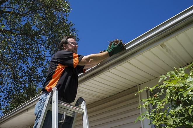 professional contractor fixing gutter on a rooftop in Country Club Hills